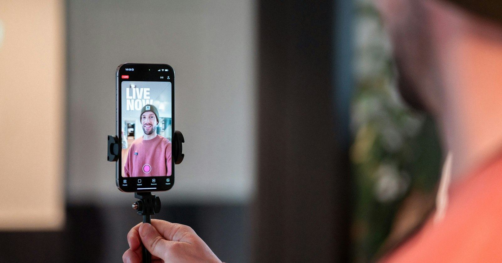 A creator filming a live video on a smartphone